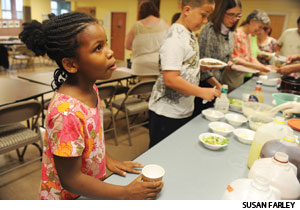 Aniya Coleman gets something to drink at a free dinner before Bridge of Peace’s Tuesday night “Family Bible School.” Giselle Coutinho, pastor, and other members create their own curriculum and connect it with living in Camden, N.J., one of the most impoverished and violent communities in the U.S. 