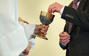 Dan Gleiter/PennLive Pollock offers the chalice during communion.