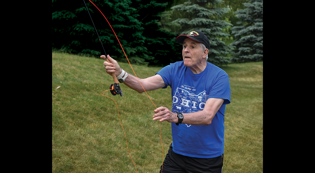 A man practices casting with a fly rod.