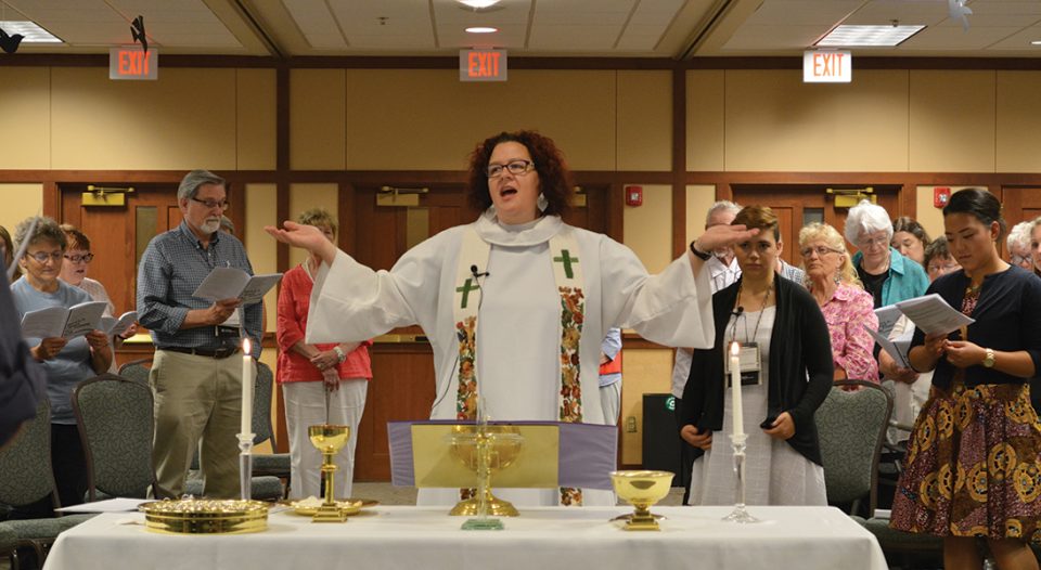 Karyn Bodenschatz, pastor of First Lutheran Church, Onalaska, Wis., presides over the communion table during the La Crosse Area Synod Assembly’s closing worship service on June 11. The liturgy for the service, “Behold, I Make All Things New,” was written by the late Ben Splichal Larson, who died in an earthquake during a mission trip to Haiti in 2010.