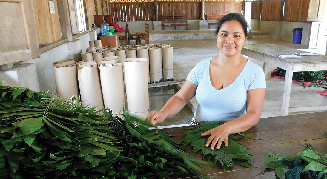Desly Marisol Acevedo sorts through palm branches in Guatemala.