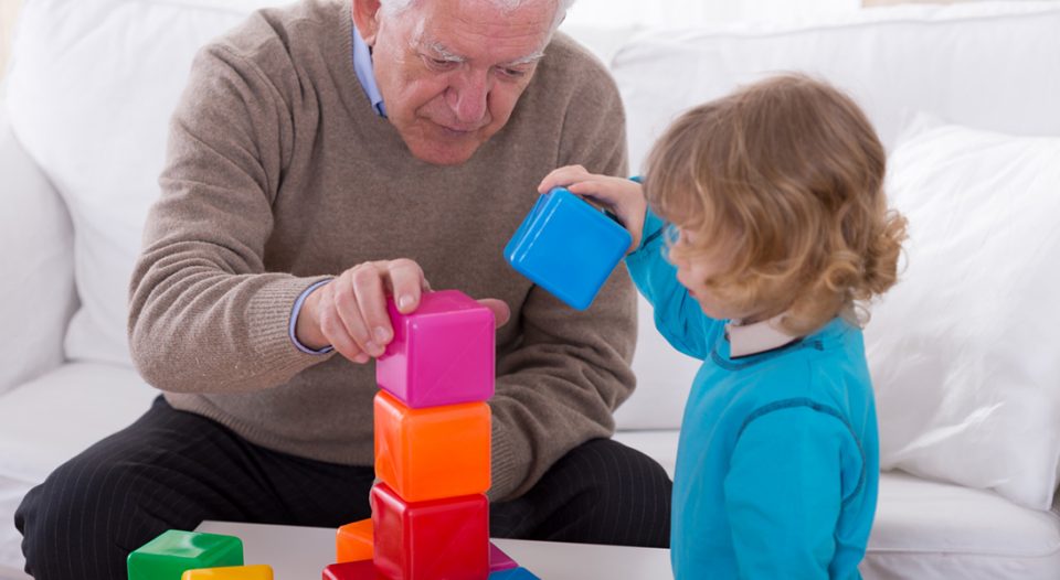 Grandpa and child playing with color cubes.