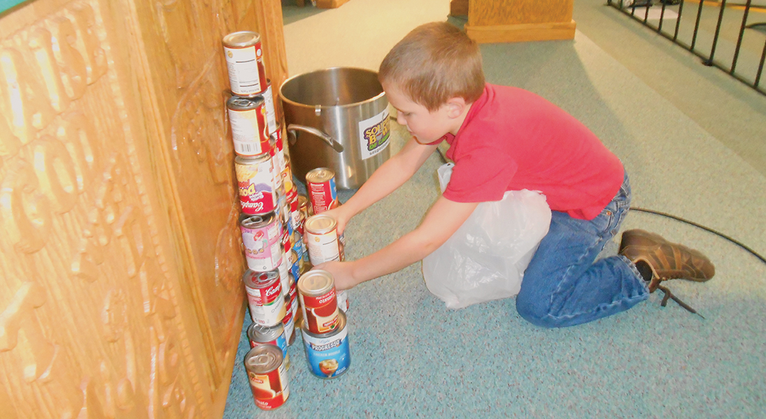 boy with canned food at church