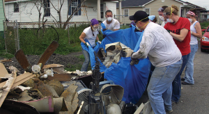 Volunteers remove debris from an abandoned house in the Lower Ninth Ward of New Orleans following the destruction done by Hurricane Katrina.