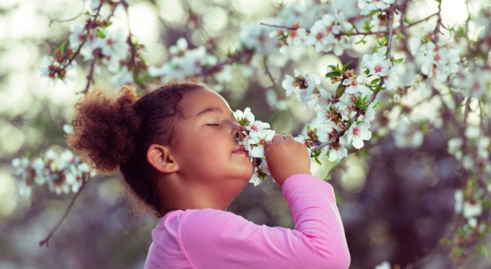 child smelling flower