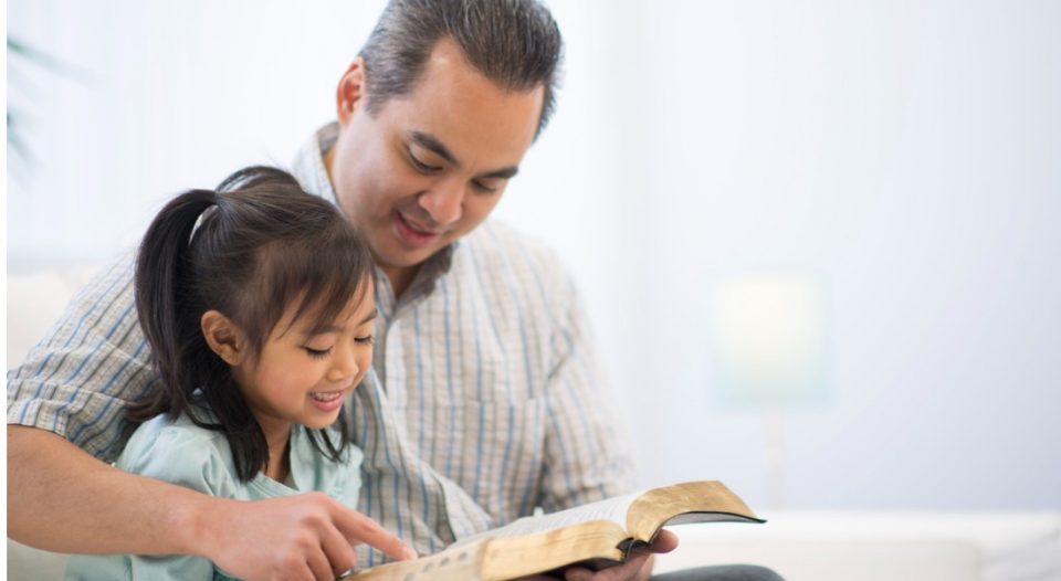daughter and father read the Bible