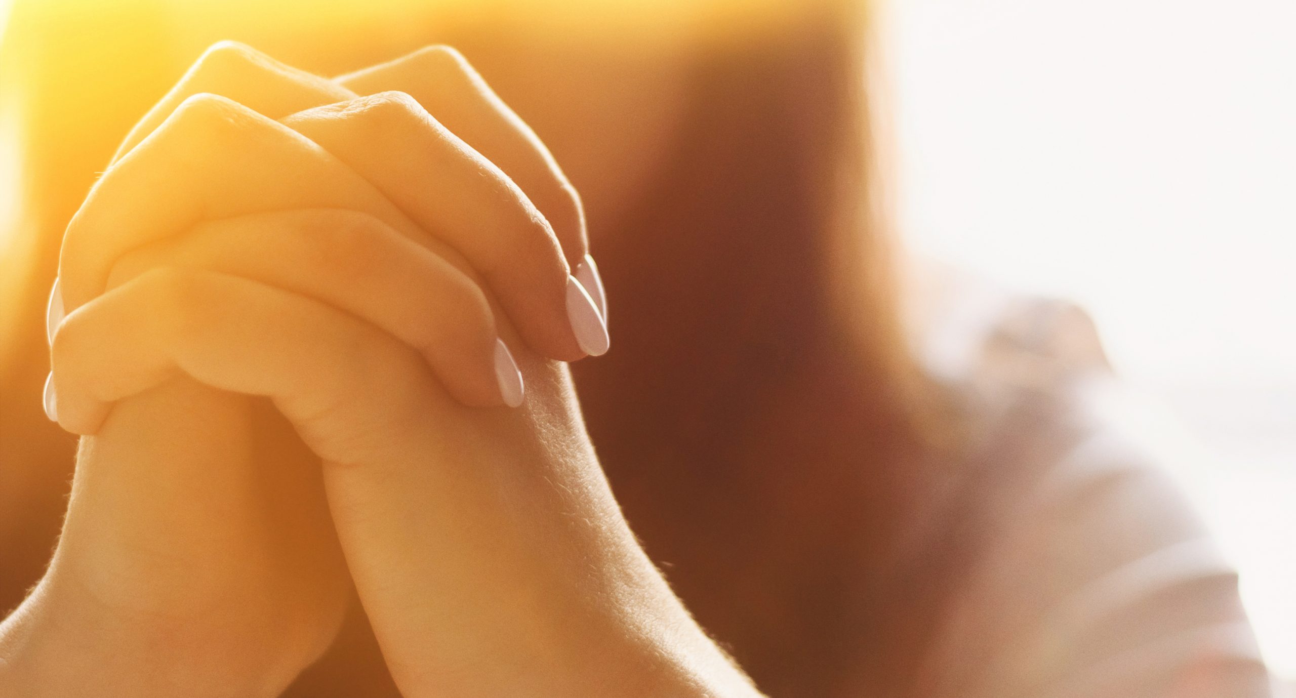 Girl folds her hands in prayer.