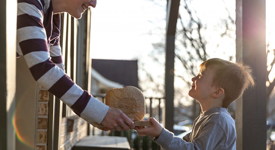 Child giving bread to neighbor