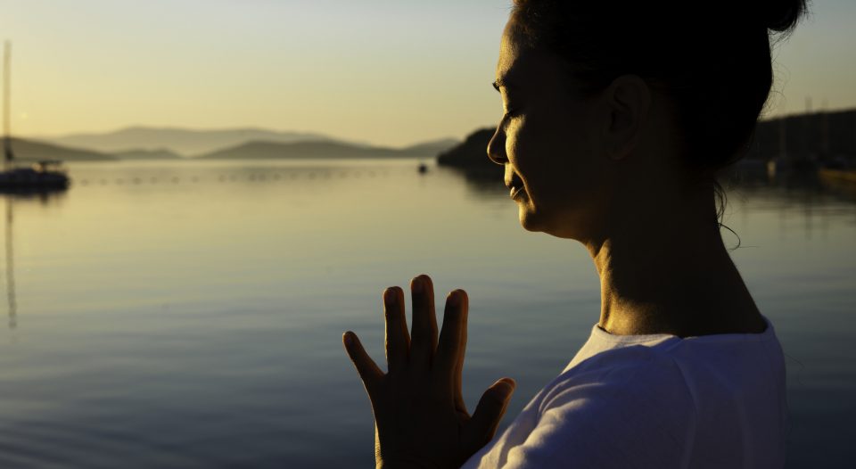Women prays at beach