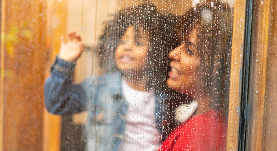 Family looks at rain out the window